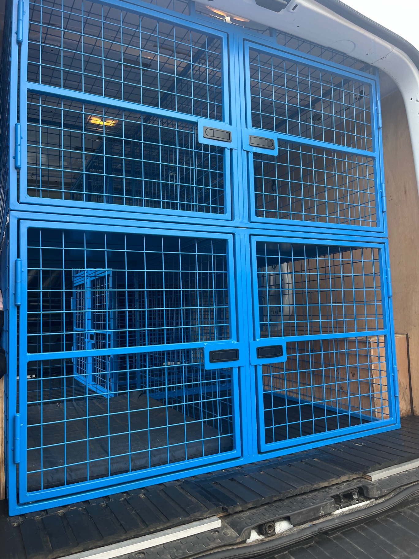 Bespoke powder-coated steel dog transport cages fitted in the rear of the van